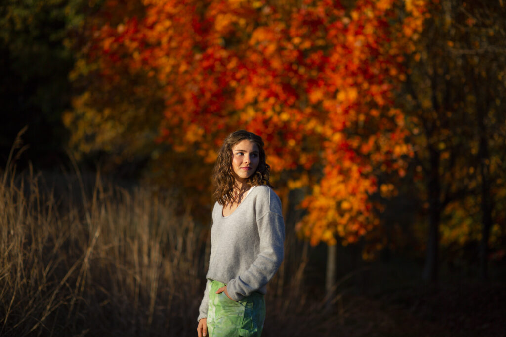 Senior portrait of a girl taken outdoors during fall foliage season at Great Brook Farm in Carlisle, MA. Photographed by Pierre Chiha Photographers.