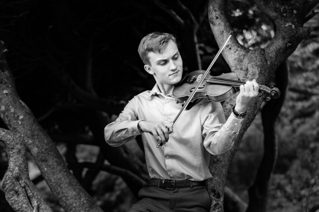 Black and white senior portrait with a violin. At the Old North Bridge in Concord, MA. Photographed by Pierre Chiha Photographers.