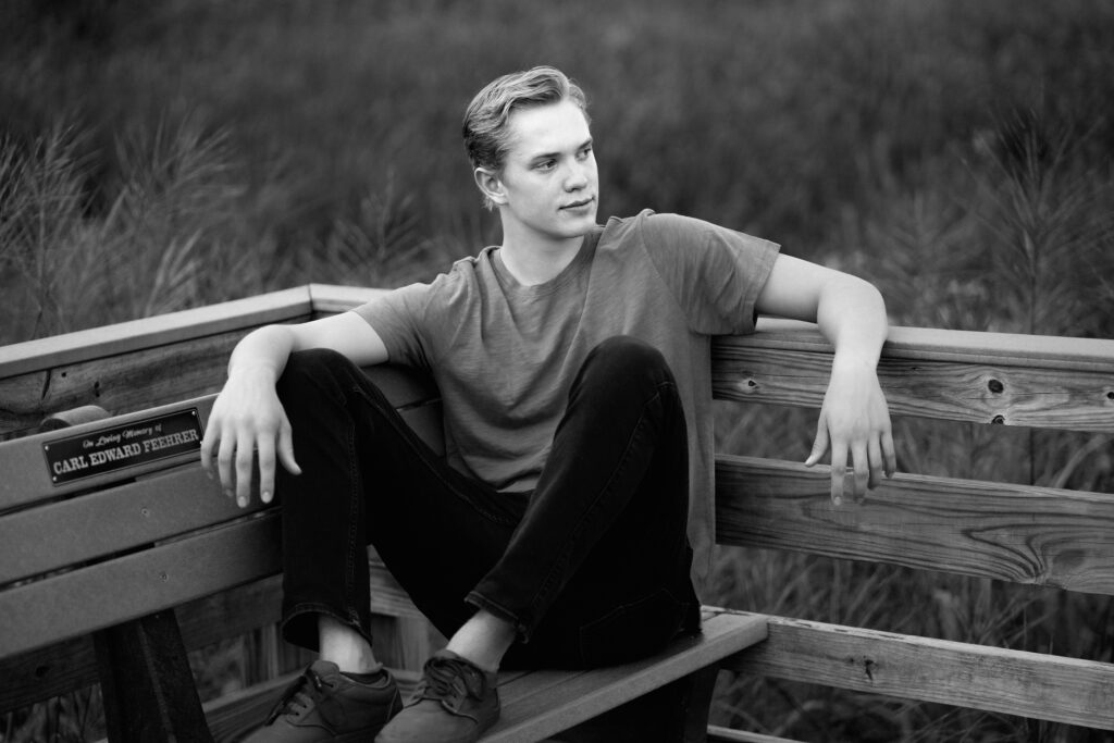 Black and white senior portrait outdoors of a boy at Great Meadows in Concord, MA. Photographed by Pierre Chiha Photographers